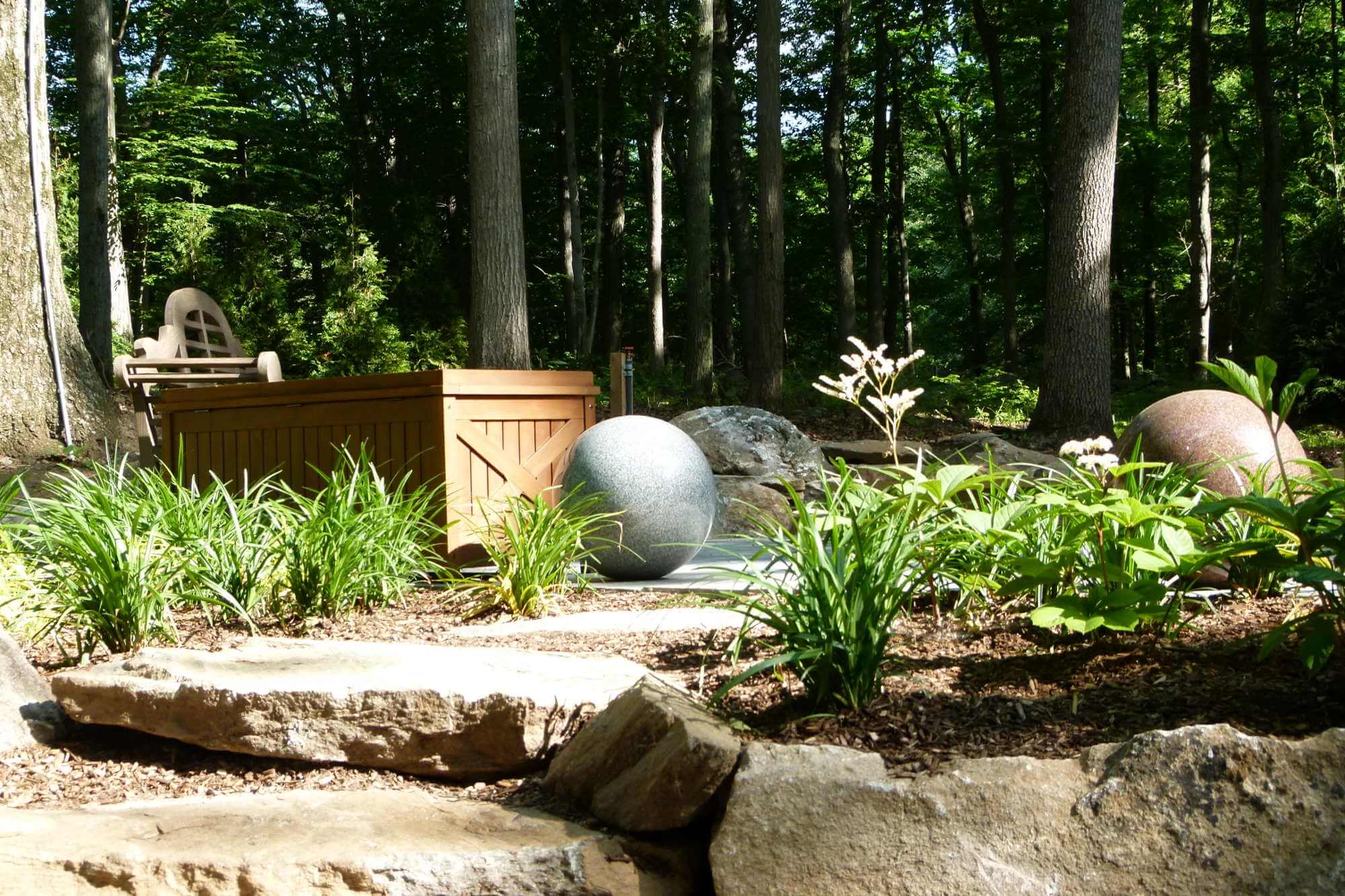 Granite orbs in sitting area with bench and stepping stones