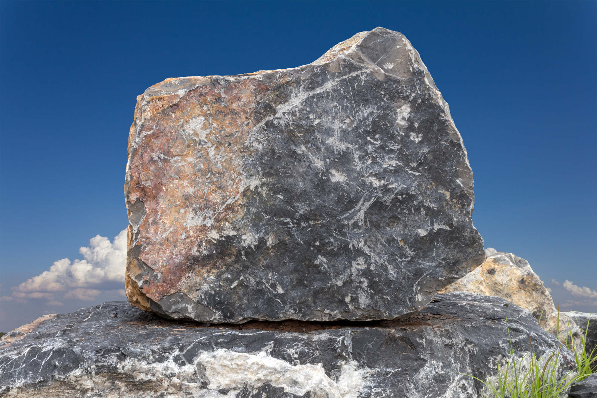 Large granite rock, with clouds and blue sky as backdrop